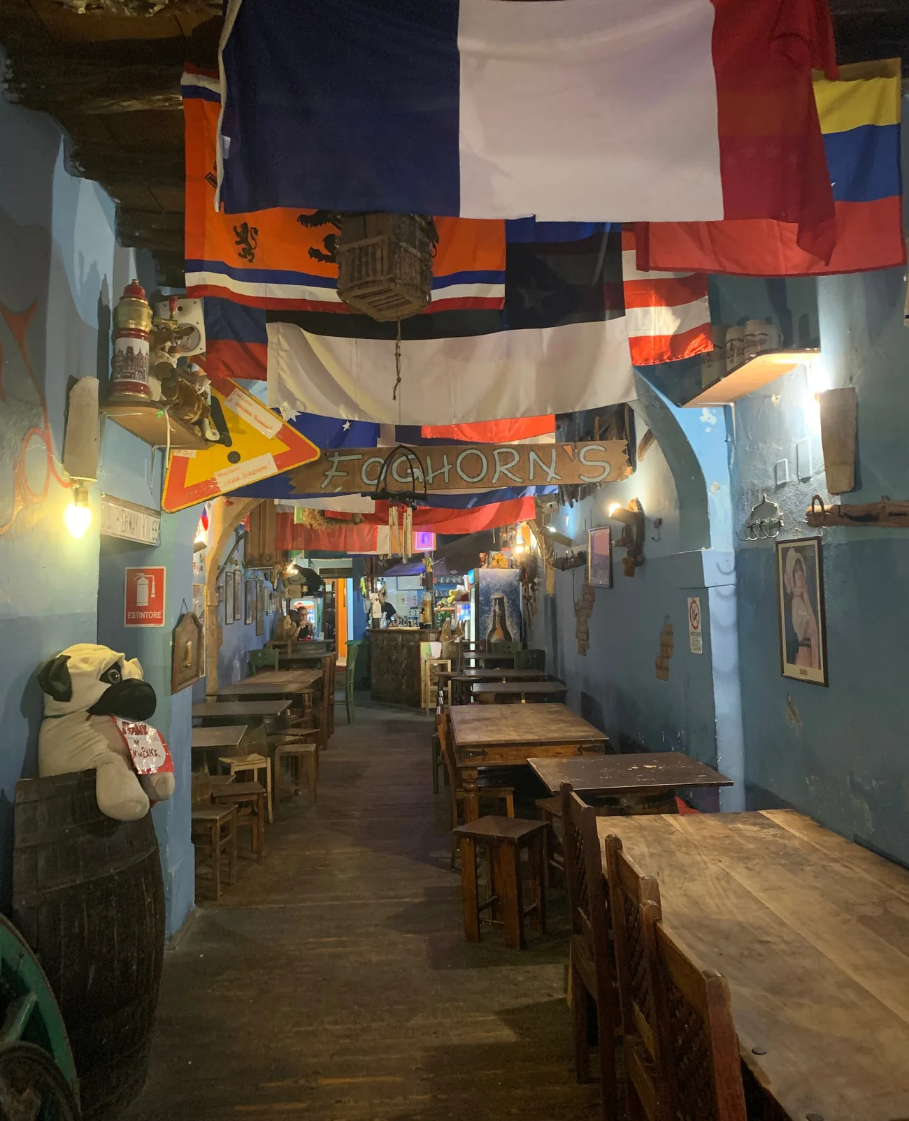 La sala del Foghorn's: l'insegna di legno con il nome del pub appesa fra le bandiere di mezzo mondo, le pareti azzurre, i tavoloni e gli sgabelli di legno