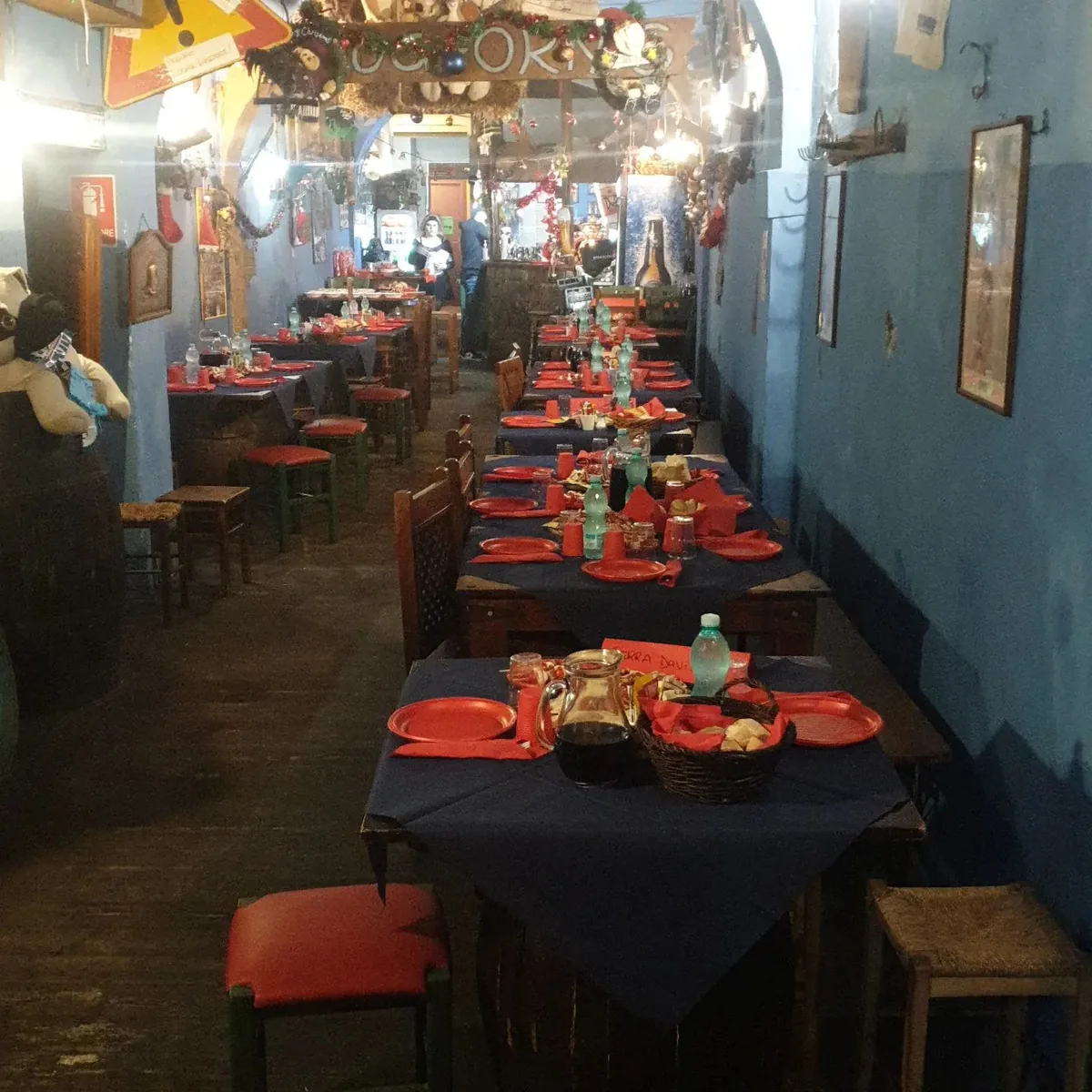 La sala del Foghorn's apparecchiata: una fila di tavoli con tovaglie blu e piatti rossi, oggetti appesi ovunque alle pareti azzurre